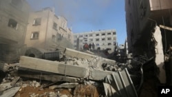 Cư dân Palestine đứng trên đống đổ nát của một tòa nhà sau vụ không kích của Israel ở Gaza City, ngày 10/7/2014.