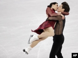 加拿大的斯科特·莫伊尔与特萨·维楚在平昌冬奥会江陵冰场的花样滑冰团体赛中进行冰上舞蹈自由舞动作。(2018年2月12日)