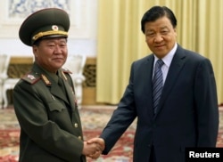中共政治局常委刘云山和访问北京的朝鲜军队总政治局局长崔龙海(Choe Ryong-hae)握手(2013年5月23日)