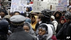 抗议者走到芝加哥市的北密西根大道,参加社区活动人士和劳工领袖组织的示威活动。(2015年11月27日)