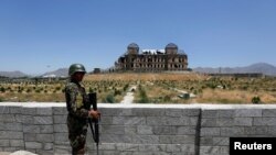 资料照片:在喀布尔历史建筑达鲁尔·阿曼宫遗址举行了重建开工仪式后,阿富汗国民军士兵守卫在现场。(2016年5月30日)