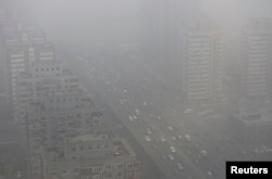 Xe cộ lưu thông trên đường phố Bắc Kinh bao phủ bởi khói mù dày đặc.