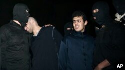 Phạm nhân Alireza Mafiha, thứ nhì từ trái, tựa đầu vào vài một nhân viên an ninh trước lúc án tử hình được thi hành,