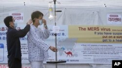 Một bệnh nhân đeo khẩu trang để tránh bị lây nhiễm bệnh MERS, hội chứng hô hấp Trung Đông, tại Bệnh viện Đại học Quốc gia Seoul, ngày 1/6/2015. Vi rút MERS trong giai đoạn đầu gây ra những triệu chứng giống bệnh cúm, như sốt và ho, nhưng sau đó nó có thể dẫn tới viêm phổi và suy thận. Chưa có thuốc điều trị hay vắc xin cho bệnh MERS.