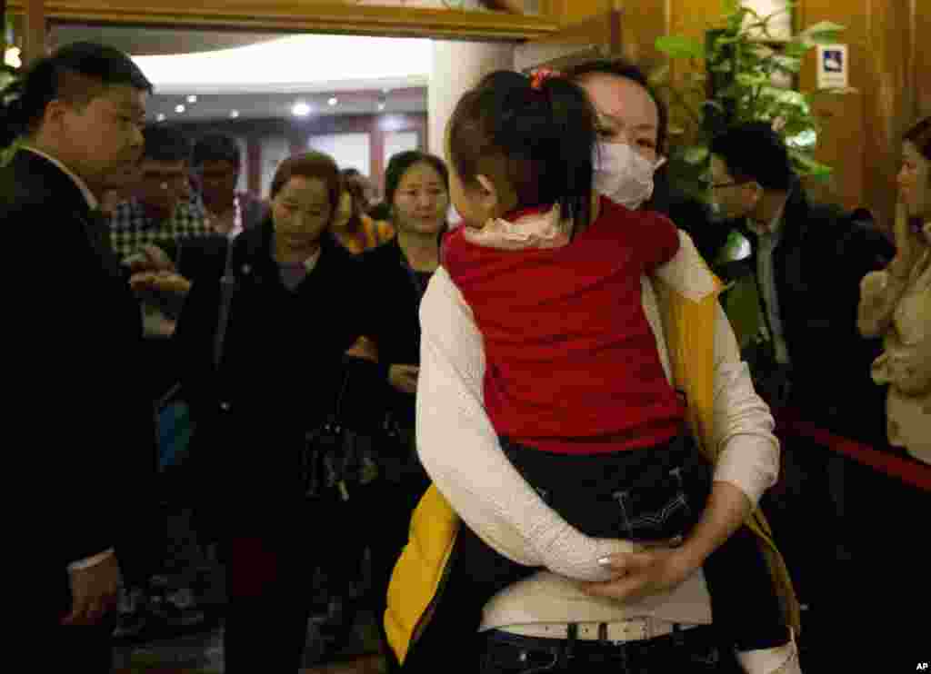 Thân nhân của hành khách trên máy bay bị mất tích bước ra từ một phòng khách sạn sau khi tham dự cuộc họp báo của hãng hàng không Malaysia tại Bắc Kinh, Trung Quốc.