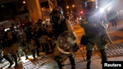 香港防暴警察在寻找抗议者时通过一个路障。(2019年10月7日)