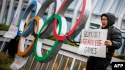 香港、新疆、彭帅和西藏,都是本次北京冬奥会无法回避的“问题”。图为西藏活动人士在位于瑞士洛桑的国际奥委会总部大门外手举抵制北京冬奥会的标语。(法新社2021年12月11日)