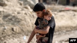 在伊拉克特种部队向被“伊斯兰国”激进分子占领的摩苏尔老城推进之际,当地民众哭喊着逃离战火。(2017年6月30日)