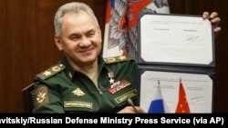 俄罗斯国防部长绍伊古在莫斯科与中国国防部长魏凤和举行视频会谈期间出示俄中军事合作协议上他的签名。(2021年11月23日)