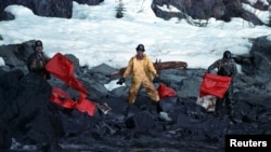 在埃克森美孚公司的瓦尔德斯油轮(Carlos Valdez)带来美国历史上最严重的石油泄漏事件之后,工作人员清理遭到石油污染的海滩。(1989年4月2日)