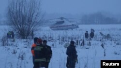 搜救人员在俄罗斯客机坠毁现场搜索。