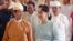 Myanmar's State Counselor Aung San Suu Kyi (R) accompanies new President Win Myint (L) to take his oath of office at parliament in Naypyidaw, March 30, 2018.
