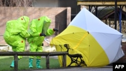 2018年3月8日,身穿防护服的英国工作人员在英国南部索尔兹伯里的斯科利帕中毒现场勘查。