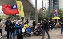 有市民在西九龙裁判法院大楼外展示青天白日旗以及港英殖民时代的龙狮旗,是国安法实施8个月以来,较少见的示威方式。 (美国之音/汤惠芸)