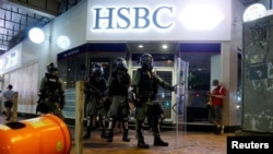 在香港反送中抗议之际,防暴警察站在湾仔街区一家汇丰银行支行的大门外。(2019年8月11日)