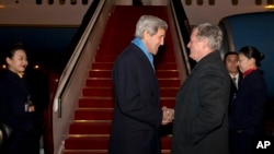 美国国务卿克里(左)2016年1月26日抵达北京访问,美国驻华大使鲍卡斯前往机场迎接。