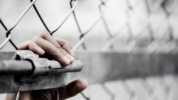 反映人口贩运问题的图库照片，一名女性手握铁丝网。(2017年12月2日)