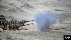 美军和菲律宾军队在联合演习中，发射M198榴弹炮击沉假想敌船。（法新社）