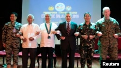 在马尼拉，美国和菲律宾官员在年度军演开幕式上手挽手（2016年4月4日）