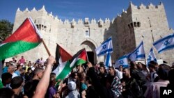 Người Israel và Palestine vẫy quốc kỳ trong lễ diễu hành kỷ niệm Ngày Jerusalem bên ngoài thành phố cổ Jerusalem.