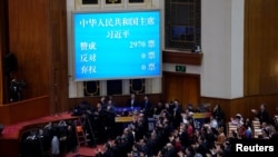 资料照:在北京人大会堂举行的全国人民代表大会第五次全体会议上,大屏幕显示习近平以赞成票2970、反对票0,弃权票0的全票通过的投票结果连任国家主席。(2018年3月17日)