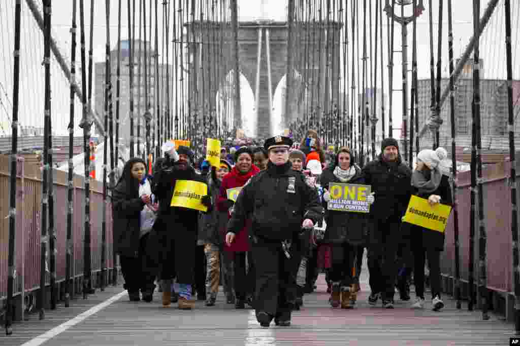 Một cảnh sát viên thành phố New York dẫn đường cho đoàn người đi từ cầu Brooklyn đến quận Manhattan trong cuộc tụ tập mang tên Cuộc Biểu Tình Của Một Triệu Bà Mẹ Chống Sử Dụng Súng. (AP)