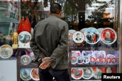 2017年10月21日,在北京举行的中共第十九届全国代表大会期间,北京一家商店展示的带有中国前国家主席毛泽东和中国国家主席习近平形象的纪念盘。