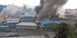 所罗门群岛的示威者在首都霍尼亚拉的中国城纵火后中国城里升起浓烟。（2021年11月25日）