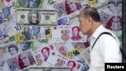 一位男子走过香港街头的一家外汇兑换商店。 (2015年8月13日)