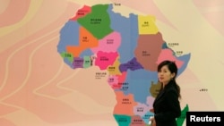 一名中国女子走过在上海召开的非洲开发银行年度会议上张贴的非洲地图 (资料照片)