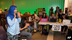 美国加州洛杉矶国际机场,活动人士和律师们为受到川普旅行限令影响的人提供法律服务。图中简易桌前贴的白纸上写着:“免费法律帮助”。