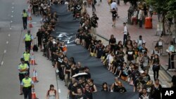 Những người phản đối cầm dải vải đen dài 500 mét tuần hành trên đường phố Hong Kong hôm Chủ nhật, để chứng tỏ họ quyết tâm muốn có phổ thông đầu phiếu thực sự, 14/9/14