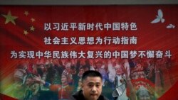 资料照片:一位行人路过北京街头宣传习近平中国梦的宣传广告牌。(2020年9月11日)