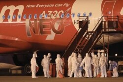 身穿防护服的泰国海军官员在乌塔堡国际机场站立在一架从中国武汉撤回侨民的飞机旁。(2020年2月4日)