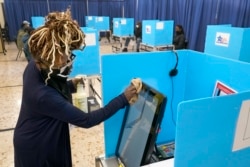 伊利诺伊州的选举工作人员擦拭电子投票机的屏幕