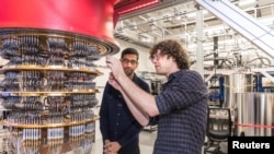 谷歌公司首席执行官桑德尔·皮查伊(左)在美加州圣塔芭芭拉实验室观看谷歌资深科学家桑科在谷歌量子计算机上工作。(2019年10月)