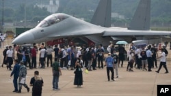 在珠海举行的中国国际航空航天博览会上,参观者在参观中国军方的电子战机歼-16D。(2021年9月29日)