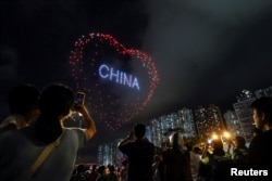 资料照:中国香港为纪念主权移交中国27周年举行的无人机表演中,无人机在天空中形成了一个心形图案。(2024年7月1日)