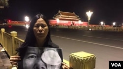 广东维权人士李小玲6月3日晚到北京天安门举牌,牌上写“光明六四,光明行”,并燃点蜡烛。 (参与网图片)。后来李小玲等人以“涉嫌寻衅滋事”为由被刑拘。