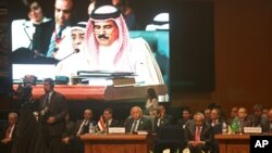 A man dressed in red-white-and-blue sits on the curb during a protest against President-elect Donald Trump, in Seattle's Capitol Hill neighborhood, Washington.