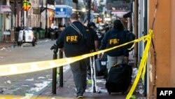 2025 年 1 月 1 日,美国路易斯安那州新奥尔良法国区,一辆白色福特 F-150 皮卡车据称撞上一群新年狂欢者,随后撞上工作电梯,联邦调查局 (FBI) 调查人员抵达现场。