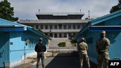 资料照片：联合国军司令部(UNC)士兵(右)和一名韩国士兵(左)在联合安全区(JSA)板门店分隔朝鲜和韩国的军事分界线前站岗。2022年10月4日拍摄。 （法新社图片）