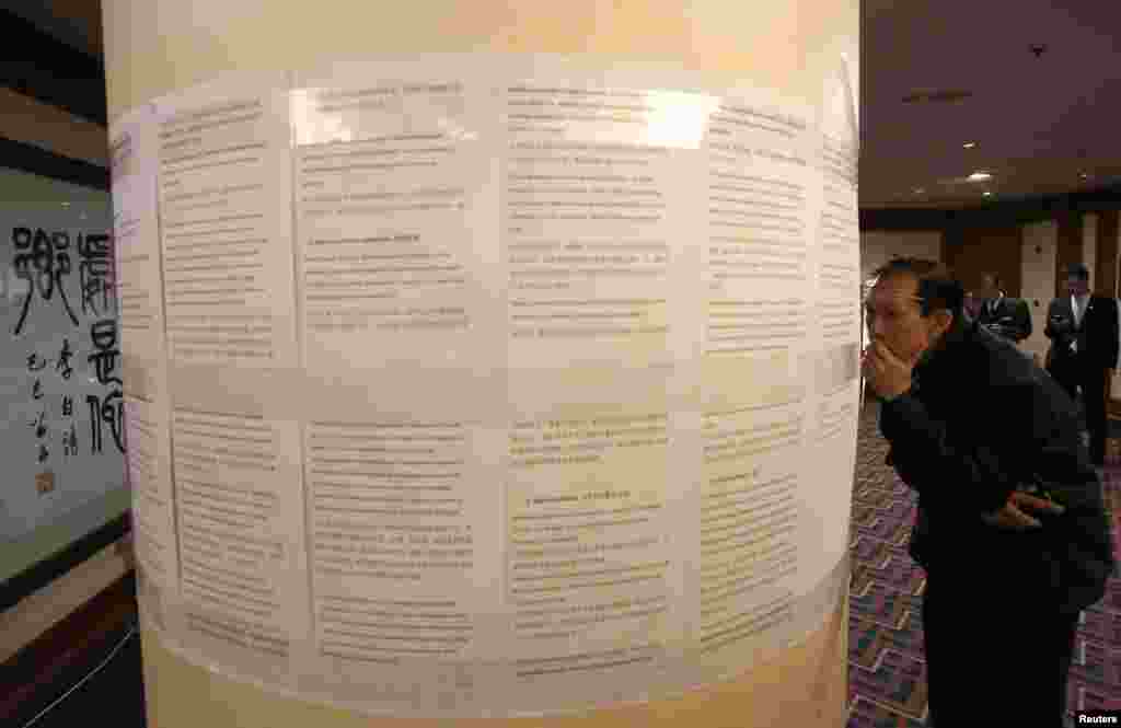 Thân nhân của một hành khách trên máy bay bị mất tích đọc thông cáo của hãng hàng không Malaysia tại một khách sạn ở Bắc Kinh.