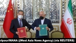 资料照片:中国外长王毅和伊朗外长扎里夫在德黑兰签署25年的合作协议(2021年3月27日)