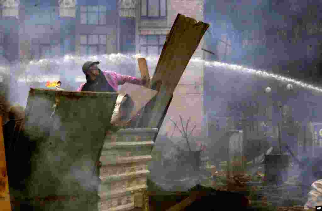 Người biểu tình chống chính phủ ném bom xăng vào cảnh sát chống bạo động tại Quảng trường Ðộc lập ở Kiev, ngày 19/2/2014.