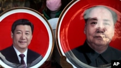 北京天安门广场附近一个纪念品商店出售的中国国家主席习近平(左)与前中共领导人毛泽东头像的磁盘。(2016年1月17日)