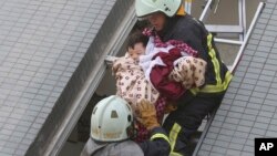 Một em nhỏ được giải cứu khỏi tòa nhà bị đổ sập vì trận động đất mạnh 6,4 độ richter ở thành phố Đài Nam, Đài Loan, hôm 6/2.