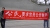2014年丁家喜推特图片显示北京几位公民在闹市西单展示要求官员公开财产的横幅。