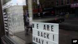 纽约布鲁克林区一个海鲜餐厅打出招牌,告诉人们5月14日恢复营业。(美联社5月11日摄)