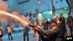 Cảnh sát chống bạo loạn bắn hơi cay vào những người biểu tình bạo động, khi xô xát xảy ra tiếp theo sau cuộc tuần hành của công nhân ở Rio de Janeiro, Brazil,